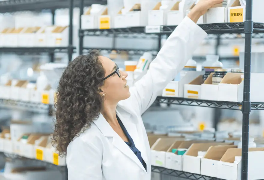Pharmacienne rangeant des produits en rayon
