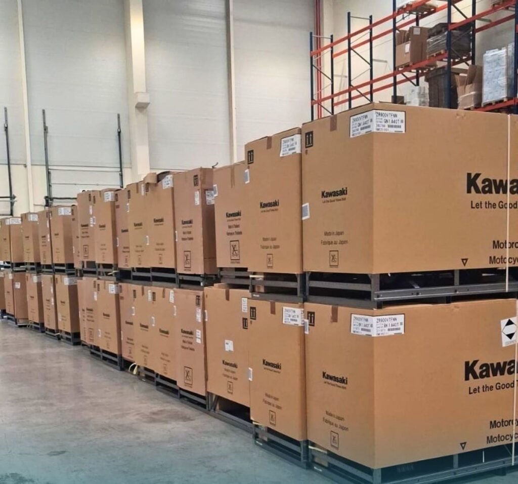 Caisses de motos LVTmoto stockées sur palettes métalliques chez Grupo Akoma